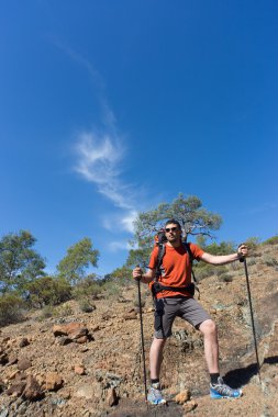 Sırt çantalı bir adam dağlarda yürüyüş yapıyor..