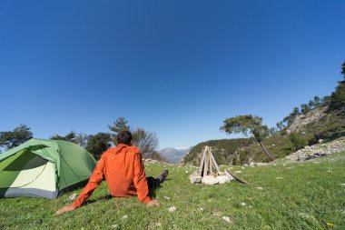 Güneşli bir yaz aylarında dağlarda çadır kamp adam.