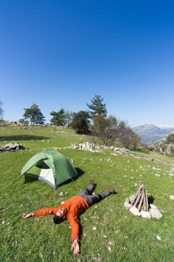 Güneşli bir yaz aylarında dağlarda çadır kamp adam.