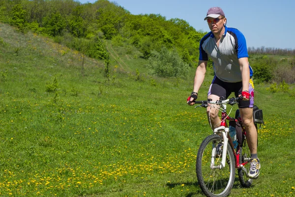 Un hombre en bicicleta que viaja en verano — Foto de Stock