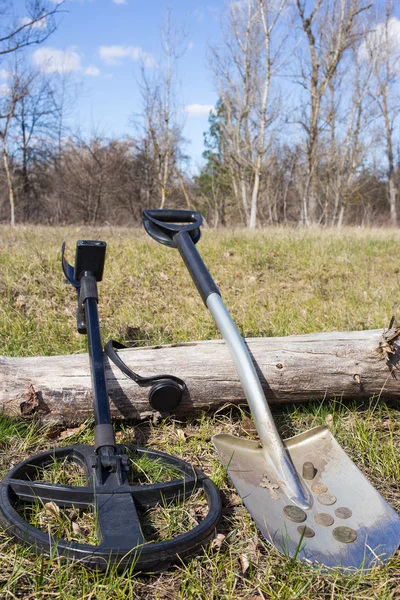 Search for coins with metal detectors and shovels.