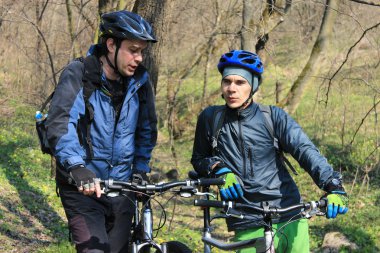 Güneşli bir günde bir dağ bisikleti ormanın içinden sürme mans