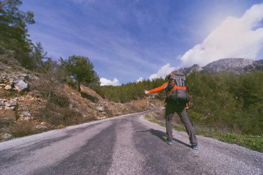 Bir sırt çantası seyahat yolu üzerinde olan bir adam. 
