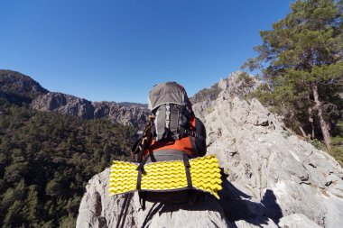Güneşli bir günde bir dağın tepesinde sırt çantası. 