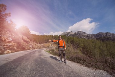 Bir sırt çantası seyahat yolu üzerinde olan bir adam. 