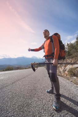 Bir sırt çantası seyahat yolu üzerinde olan bir adam. 