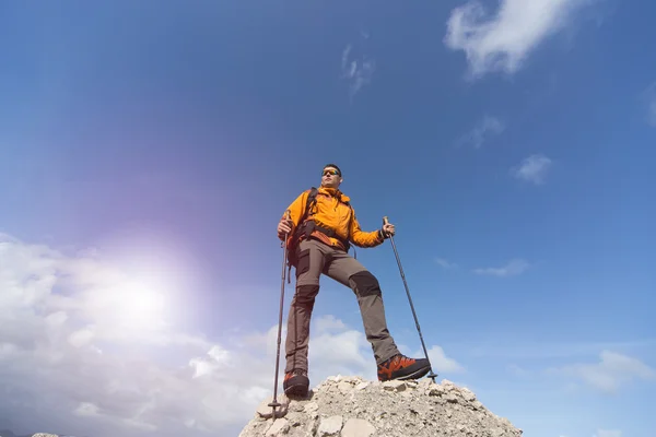 Молодий чоловік з рюкзаком на вершині гори в сонячний день . — стокове фото
