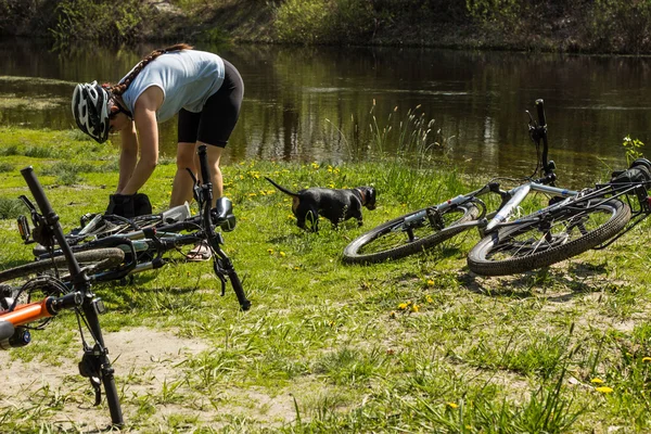 Men repairing a wheel on mountain bikes in the nature in the summer.