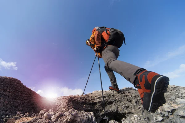 Junger Mann mit Rucksack auf einem Berggipfel an einem sonnigen Tag. — Stockfoto