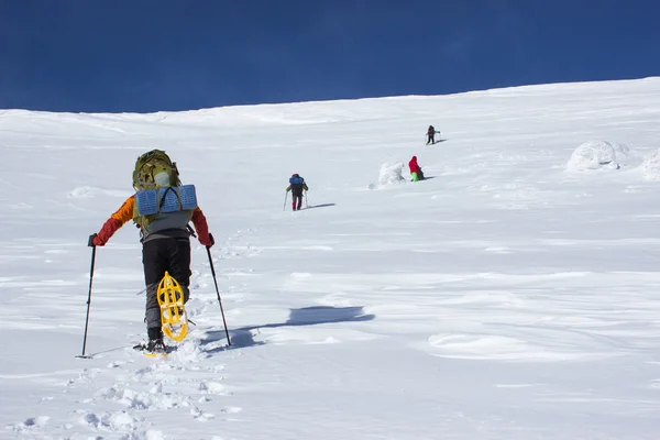 Winterwandelen in de bergen in sneeuwschoenen. — Stockfoto