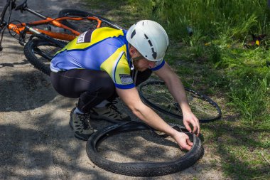 Yaz aylarında dağ bisikleti doğada bir tekerlek tamiri erkek.