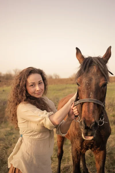 Beautiful girl with a horse outdoors in the countryside. — Stock Photo, Image