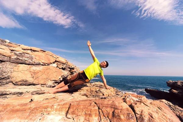 Joven haciendo ejercicios de yoga en la playa. — Foto de Stock