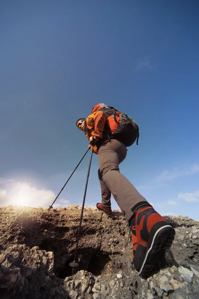 Jovem com mochila no topo de uma montanha em um dia ensolarado . — Fotografia de Stock