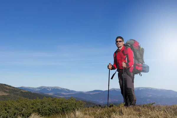 Wandelaar wandelen in de bergen een zonnige dag. — Stockfoto