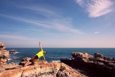 Genç adam plajda yoga egzersizleri yapıyor.. 