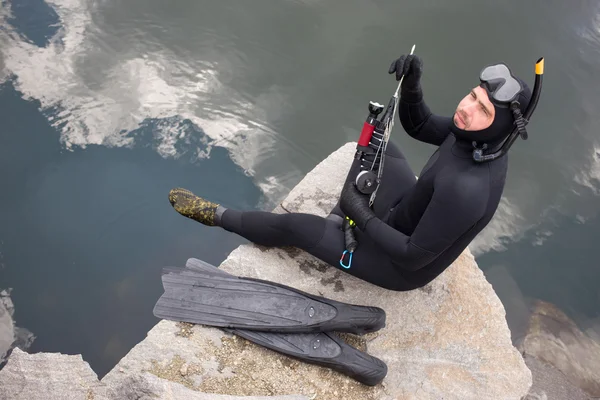 Hombre vestido como un cazador con una pistola de buceo bajo el agua . — Foto de Stock