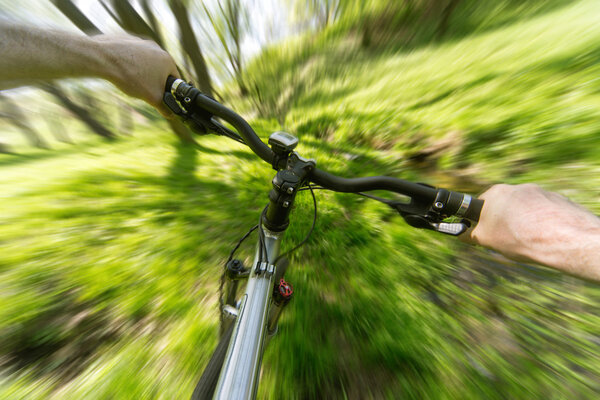 Male cyclist traveling through the woods in early spring. 