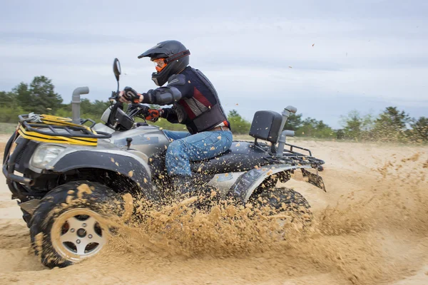 A corrida em condições difíceis na areia em uma moto quad . — Fotografia de Stock