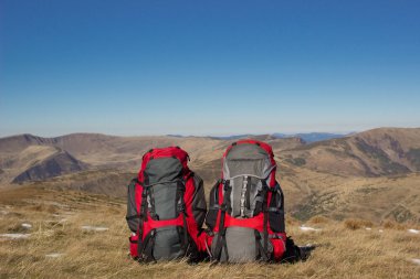 Sırt çantası dağlarda bir güneşli yaz günü kamp. 