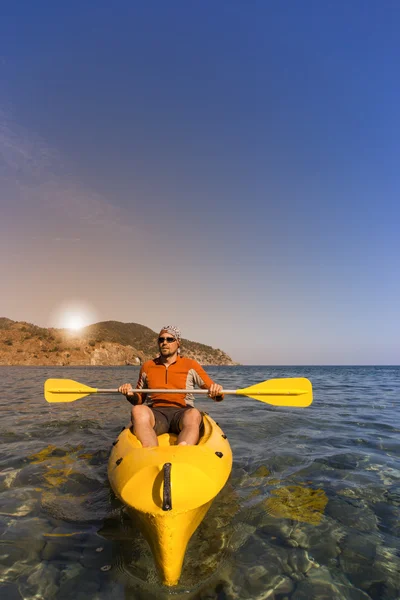Un homme voyageant en canot le long de la côte en été . — Photo