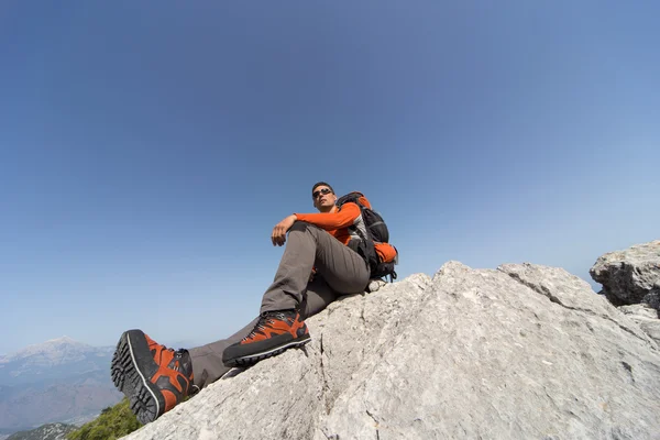 Hombre caminando en las montañas en un día soleado . — Foto de Stock