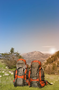 Dağların manzarasına sahip dağlarda sırt çantaları. 