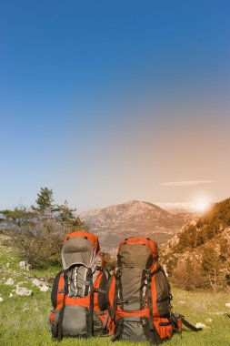 Dağların manzarasına sahip dağlarda sırt çantaları. 