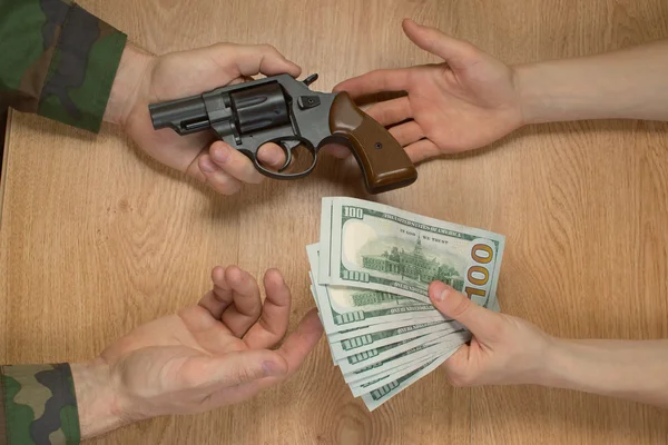 Transfers of money in exchange for a gun under certain conditions, sitting at the table.