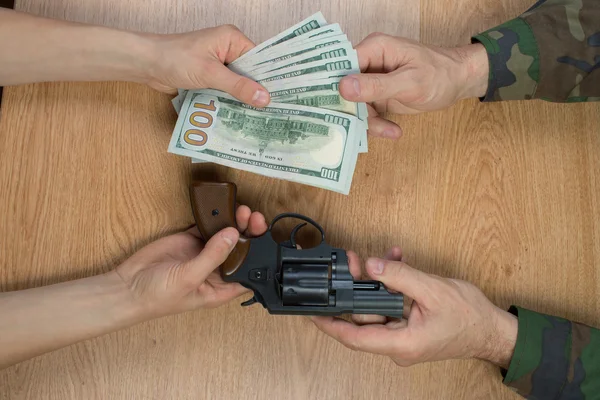 Transferencias de dinero a cambio de un arma bajo ciertas condiciones, sentado a la mesa . —  Fotos de Stock