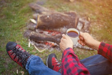 Adam ile yaz ormandaki bir kamp ateşi kamp alanında 