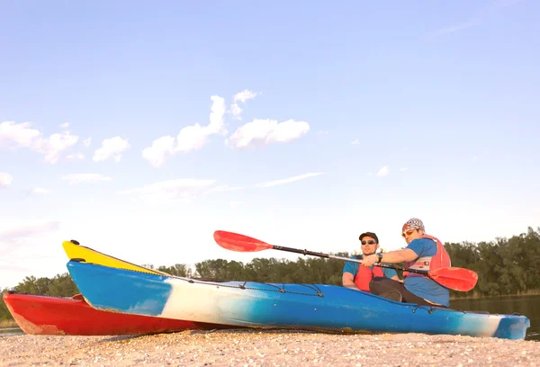 Männer fahren mit dem Kanu auf dem Fluss im Sommer an einem sonnigen Tag. — Stockfoto