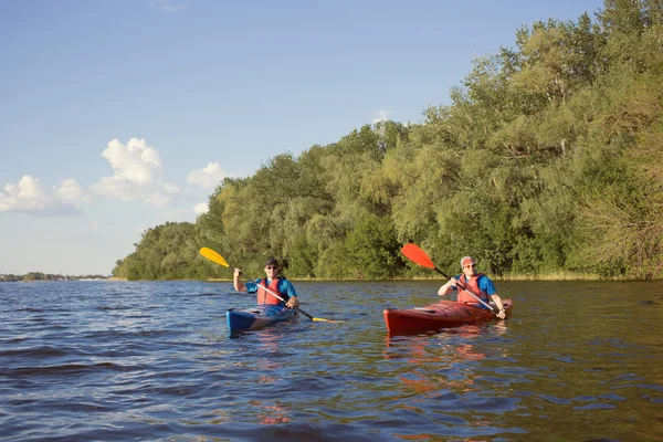 Dos chicos viajan por el río en un kayak en el verano . —  Fotos de Stock