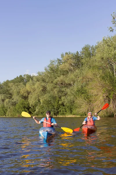 Dos chicos viajan por el río en un kayak en el verano . — Foto de Stock
