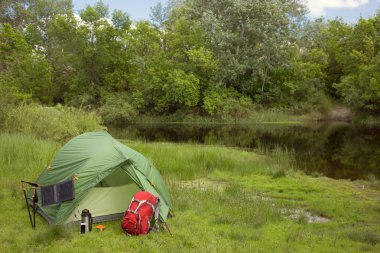 Nehir kıyısında ormanda kamp.