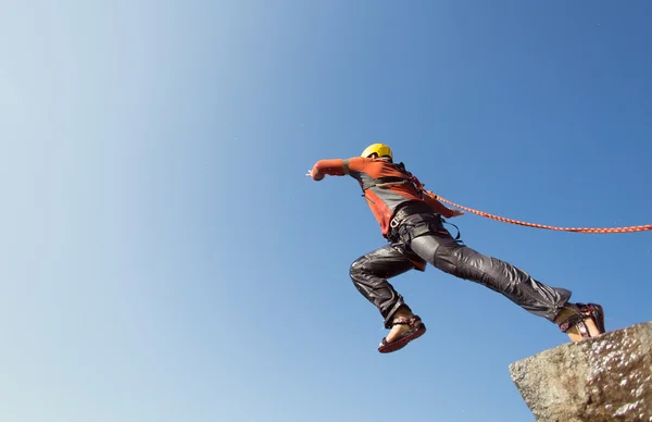 Jump off the cliff with a rope. — Stock Photo, Image