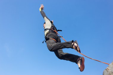 Adam bir ip ile bir uçurumdan atlama.