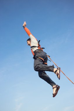 Adam bir ip ile bir uçurumdan atlama.