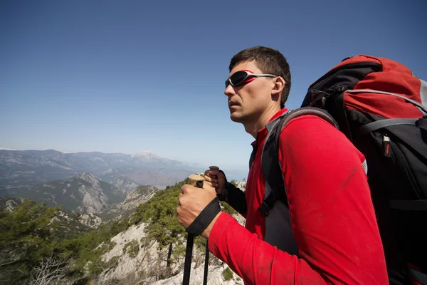 Man op een zonnige dag wandelen in de bergen. — Stockfoto