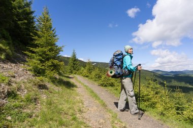 Güneşli yaz gününde bir sırt çantası ile dağlarda hiking