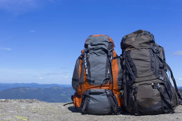 Campeggio con zaini in montagna contro il cielo blu . — Foto Stock