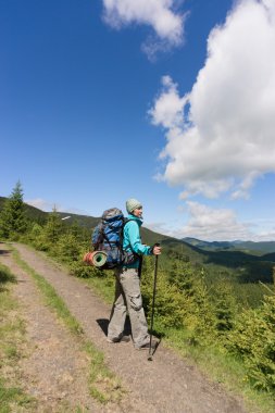 Güneşli yaz gününde bir sırt çantası ile dağlarda hiking