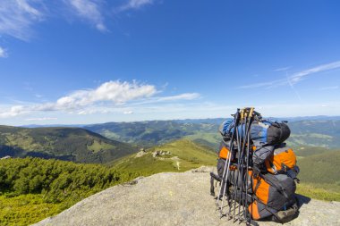 Mavi gökyüzüne karşı dağlarda sırt çantaları ile kamp.