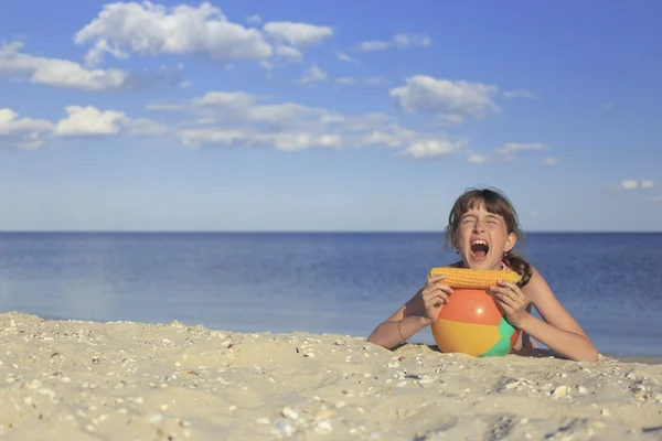 Happy children on the beach eating sweet corn. — Stock Photo, Image