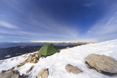 Dağlarda bir sırt çantası ve çadır kamp kış.