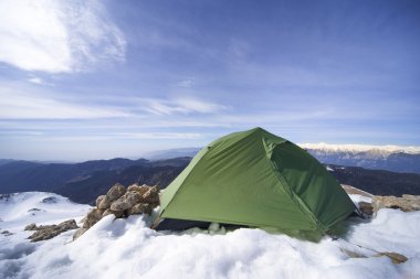 Dağlarda bir sırt çantası ve çadır kamp kış.