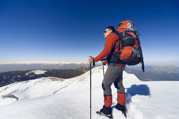 Winterwandelen in de bergen met een rugzak. — Stockfoto