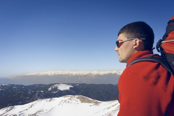 Winterwandelen in de bergen met een rugzak. — Stockfoto