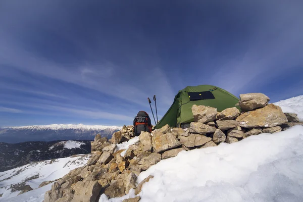 Acampamento de inverno nas montanhas com uma mochila e tenda . — Fotografia de Stock