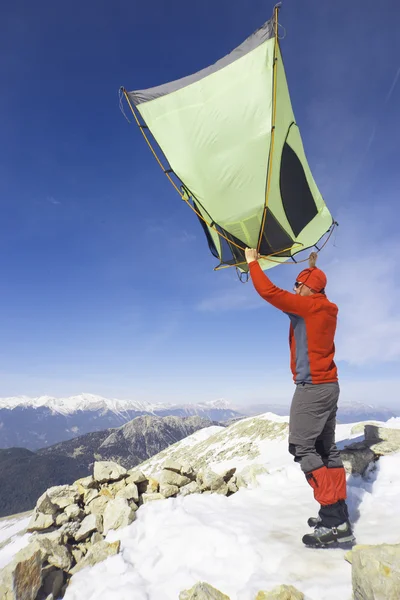 Winter camping in the mountains with a backpack and tent.